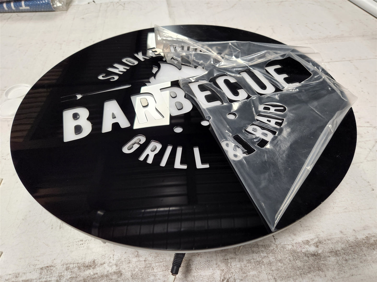 insegna a led retroilluminata in  plexiglas nero con logo insegna neon rgb personalizzata oer negozio locale moderno in plex luminosa